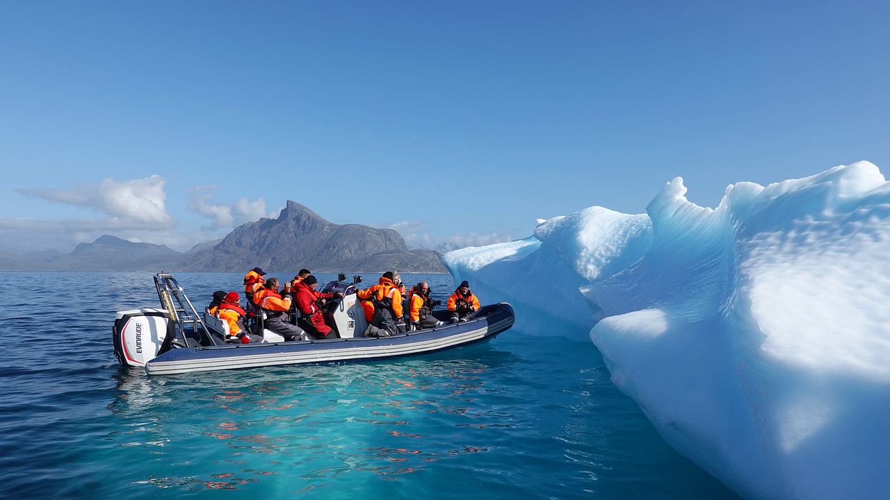 Group of so many people sitting on a boat going towards a snow rock